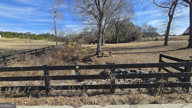 view of yard with a rural view and fence