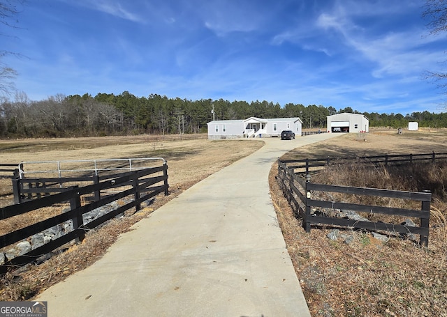 exterior space with an outbuilding, a garage, and a rural view