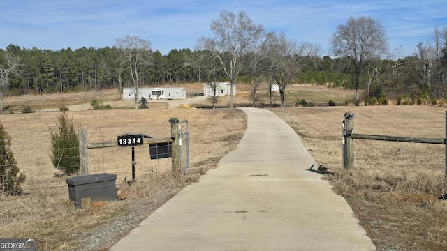 surrounding community with a rural view and fence