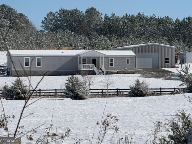 snow covered rear of property with a garage