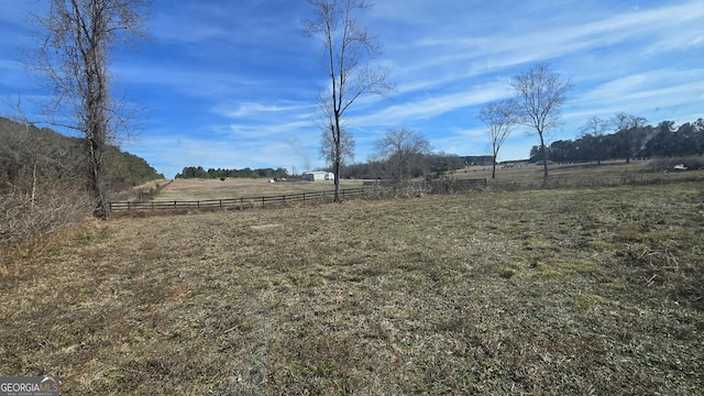 view of yard featuring fence and a rural view