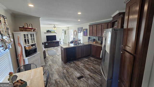 kitchen featuring black dishwasher, dark wood finished floors, freestanding refrigerator, a peninsula, and a sink