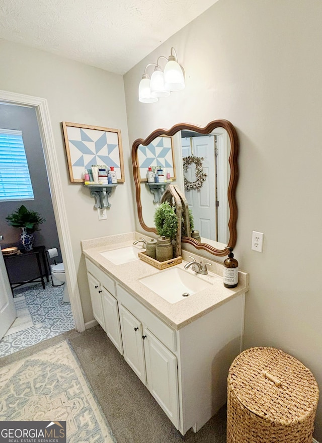 bathroom with vanity, a textured ceiling, and toilet