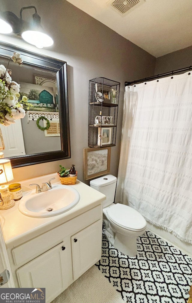 bathroom with tile patterned flooring, vanity, and toilet