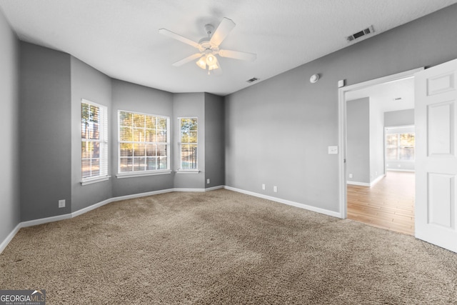 carpeted spare room with ceiling fan