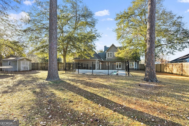 view of yard featuring a storage shed and a fenced in pool