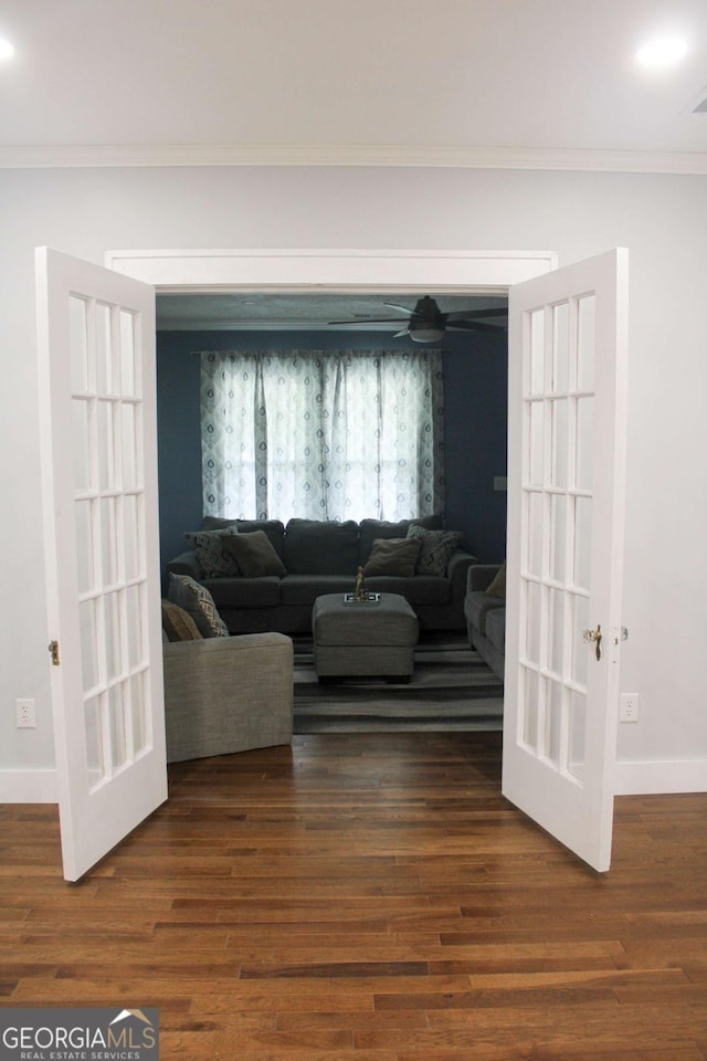 living room featuring dark wood-type flooring, ornamental molding, and french doors