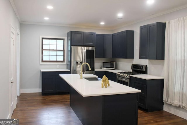 kitchen with dark wood-type flooring, sink, crown molding, appliances with stainless steel finishes, and a kitchen island with sink