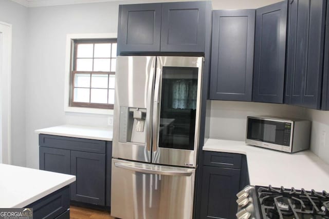 kitchen featuring crown molding, appliances with stainless steel finishes, and light hardwood / wood-style flooring