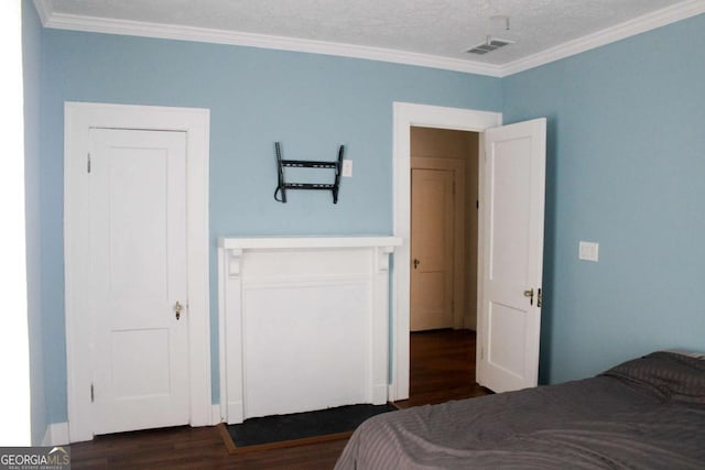 bedroom with a closet, ornamental molding, dark hardwood / wood-style floors, and a textured ceiling