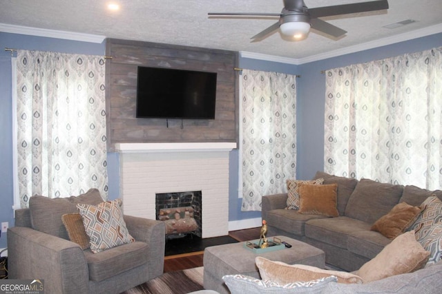 living room with ceiling fan, hardwood / wood-style flooring, ornamental molding, and a textured ceiling