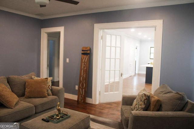 living room with hardwood / wood-style flooring, ornamental molding, and ceiling fan