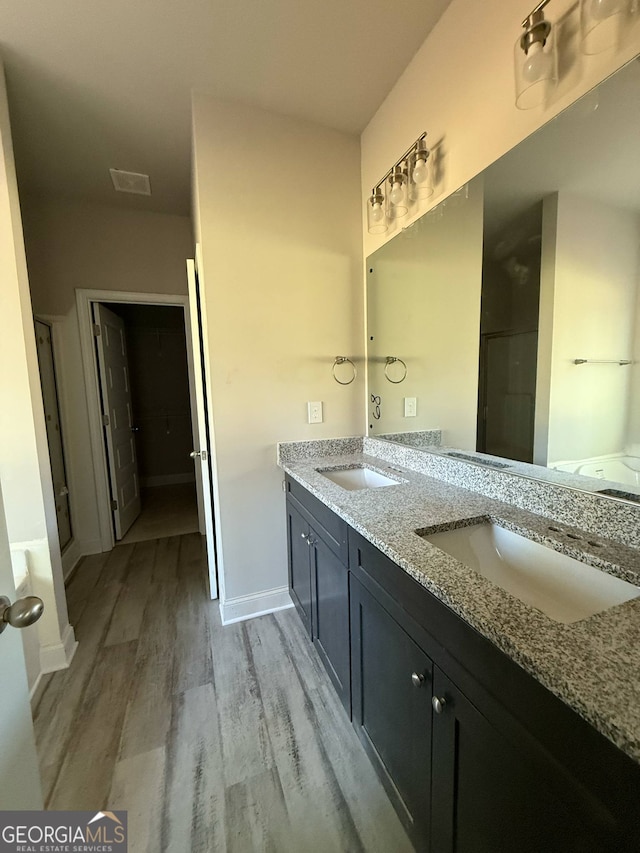 148 Asa Moseley Rd, Mcdonough, GA 30252 - bathroom with wood finished floors, double vanity, a stall shower, and baseboards