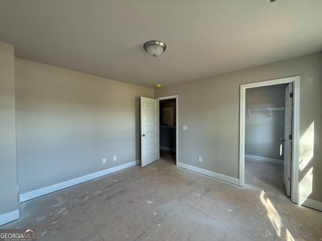 148 Asa Moseley Rd, Mcdonough, GA 30252 - unfurnished bedroom with a walk in closet, a closet, and baseboards