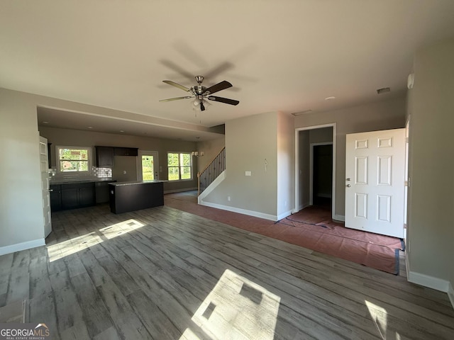 148 Asa Moseley Rd, Mcdonough, GA 30252 - unfurnished living room featuring stairway, wood finished floors, a ceiling fan, and baseboards