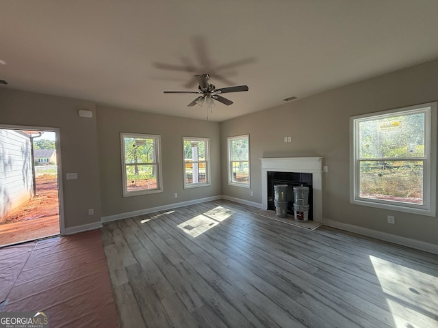 148 Asa Moseley Rd, Mcdonough, GA 30252 - unfurnished living room with a fireplace with raised hearth, baseboards, ceiling fan, and wood finished floors