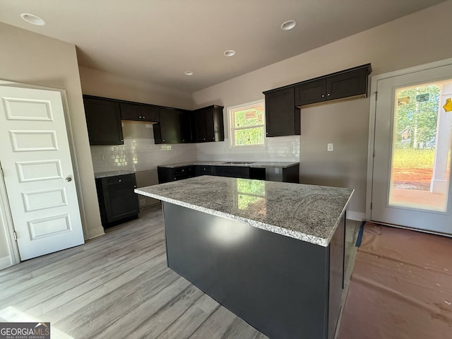 148 Asa Moseley Rd, Mcdonough, GA 30252 - kitchen with decorative backsplash, light stone counters, a center island, recessed lighting, and light wood finished floors