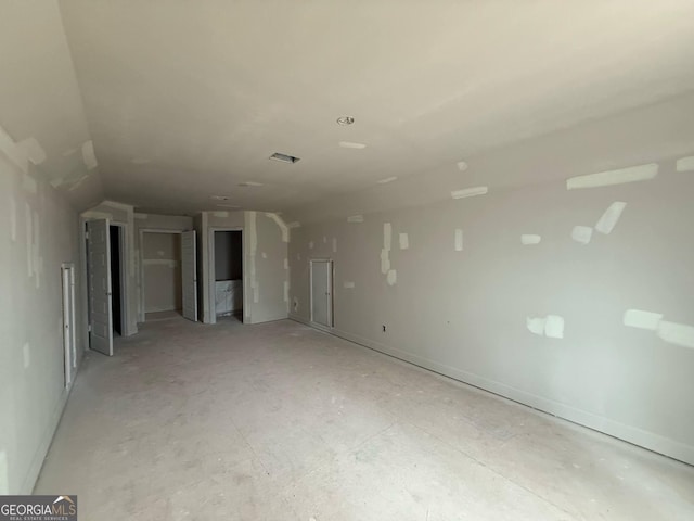 unfurnished room featuring lofted ceiling and baseboards