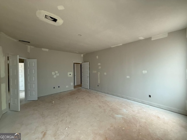 empty room with concrete flooring and baseboards