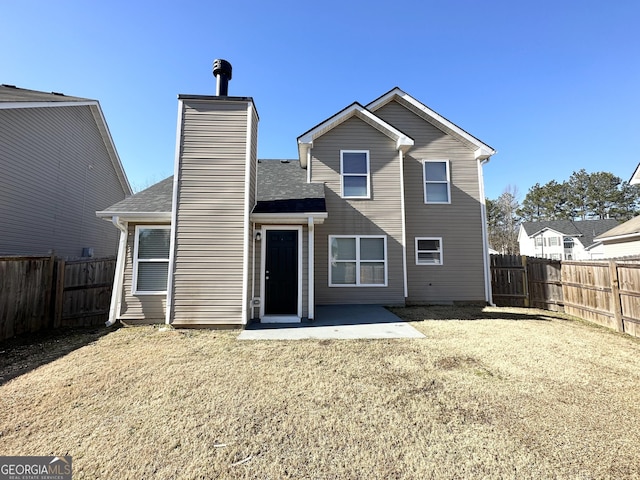 rear view of house with a lawn and a patio