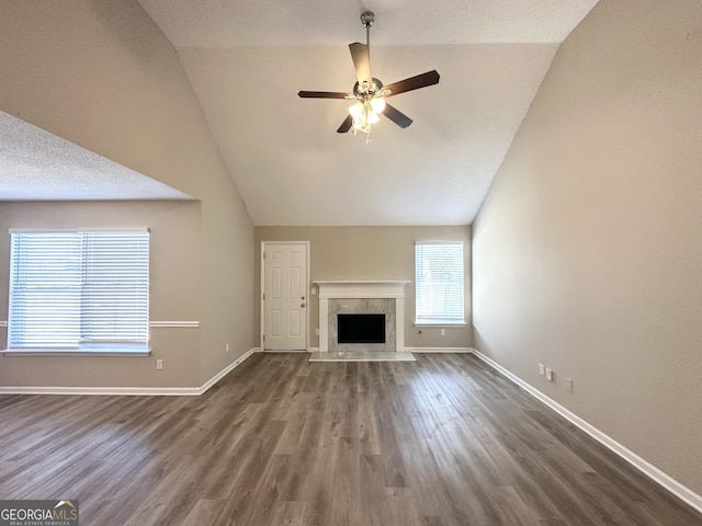 unfurnished living room featuring hardwood / wood-style floors, a high end fireplace, vaulted ceiling, and ceiling fan