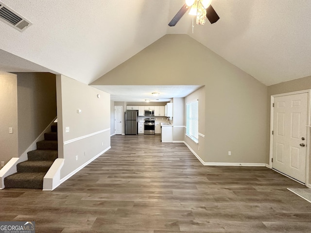 unfurnished living room featuring lofted ceiling, sink, wood-type flooring, a textured ceiling, and ceiling fan