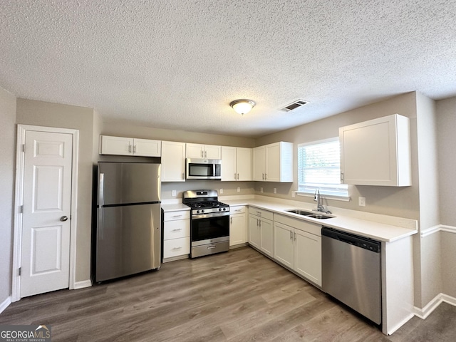 kitchen with white cabinetry, appliances with stainless steel finishes, and sink