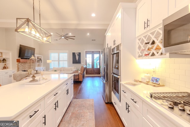 kitchen featuring white cabinetry, pendant lighting, appliances with stainless steel finishes, and backsplash