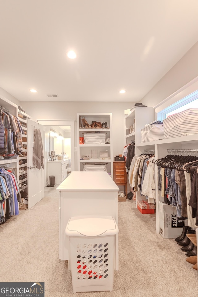 walk in closet featuring light carpet