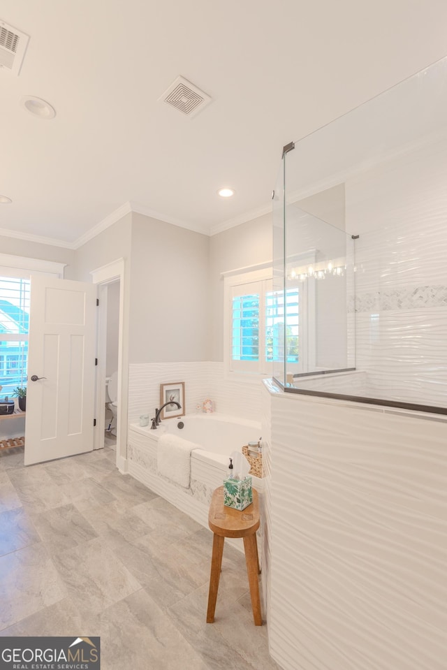 bathroom with crown molding, plenty of natural light, toilet, and separate shower and tub