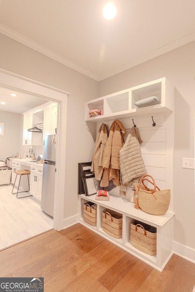 mudroom featuring crown molding and light hardwood / wood-style flooring