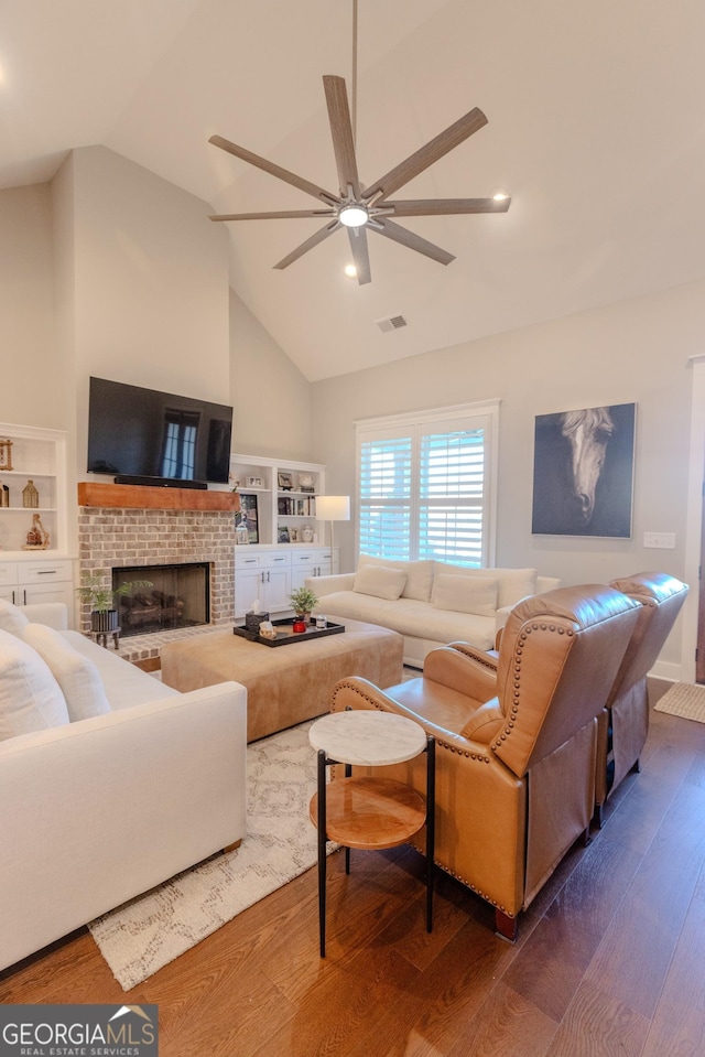 living room featuring lofted ceiling, a fireplace, dark wood-type flooring, and ceiling fan