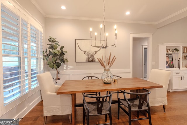 dining room with dark wood-type flooring, ornamental molding, and a chandelier