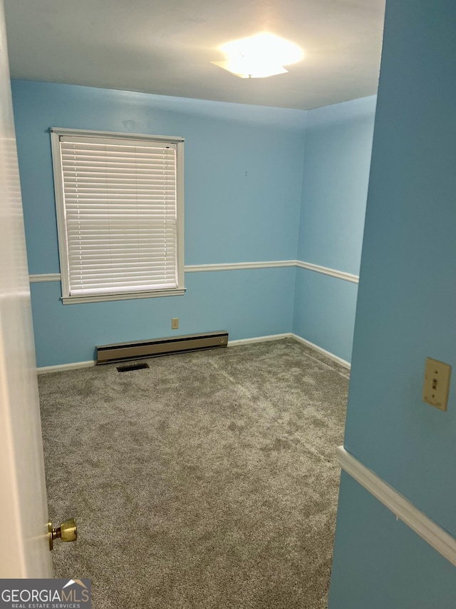 unfurnished room with a baseboard radiator and carpet