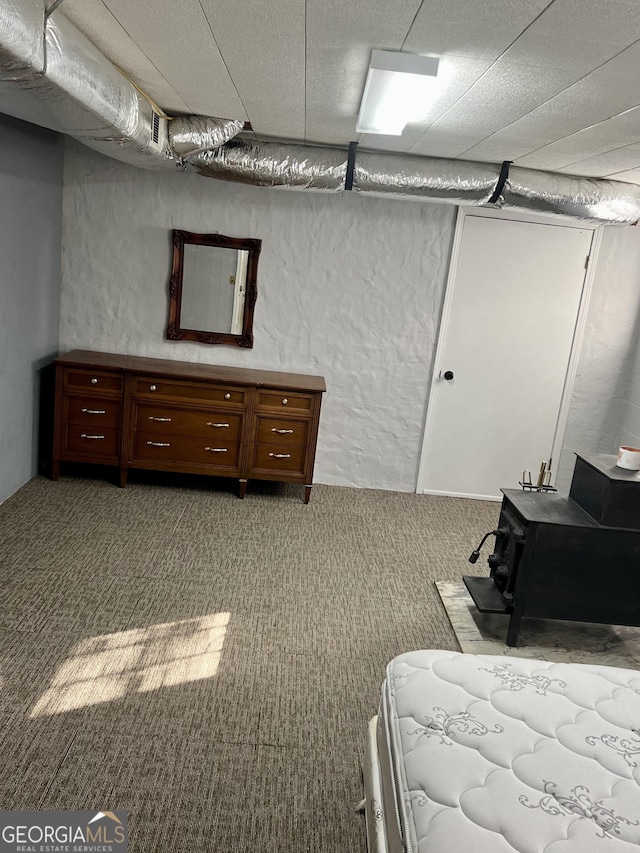 carpeted bedroom featuring a wood stove