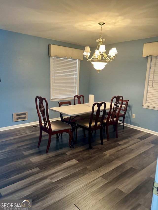 dining area with a chandelier and dark hardwood / wood-style flooring