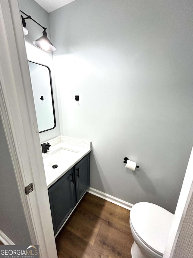 bathroom featuring vanity, hardwood / wood-style floors, and toilet