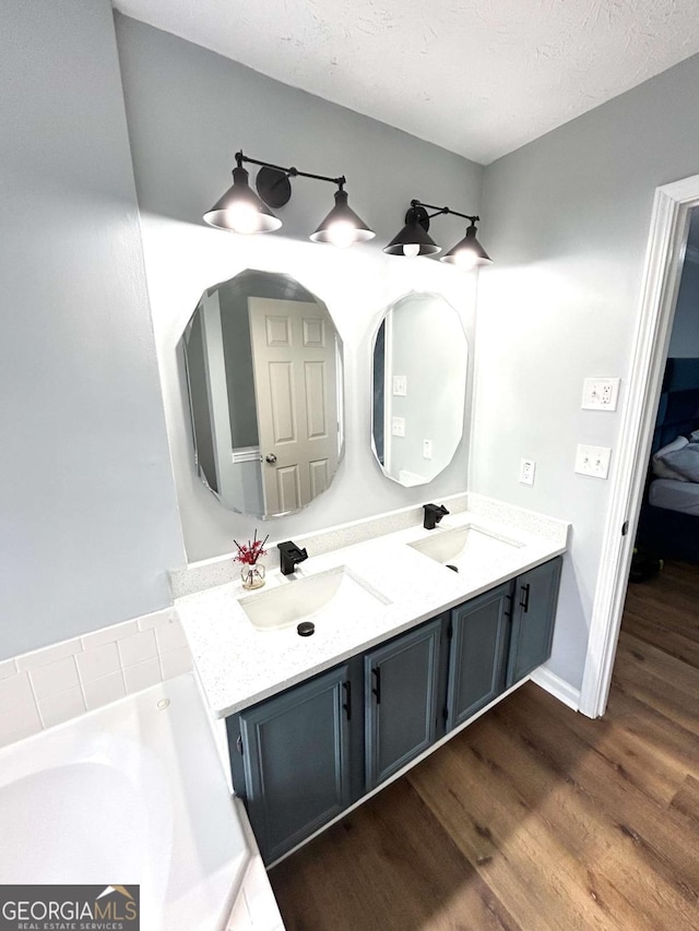 bathroom featuring vanity, wood-type flooring, and a textured ceiling