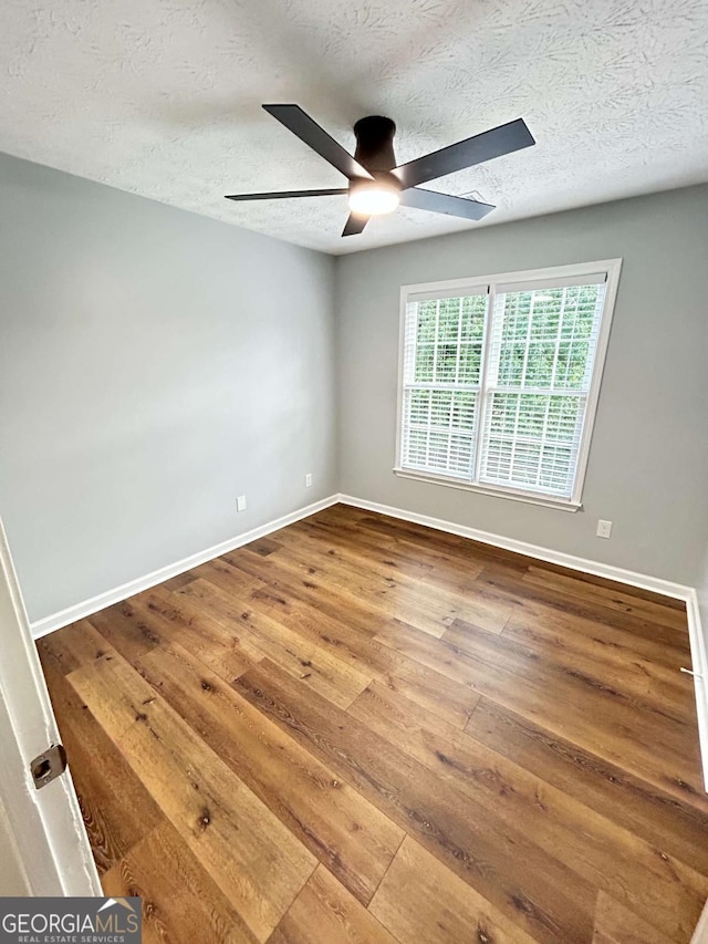 unfurnished room featuring ceiling fan, hardwood / wood-style flooring, and a textured ceiling