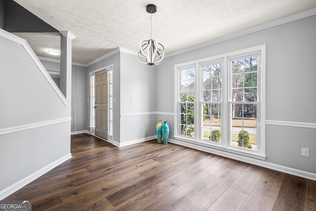 unfurnished dining area featuring dark wood finished floors, a notable chandelier, and baseboards