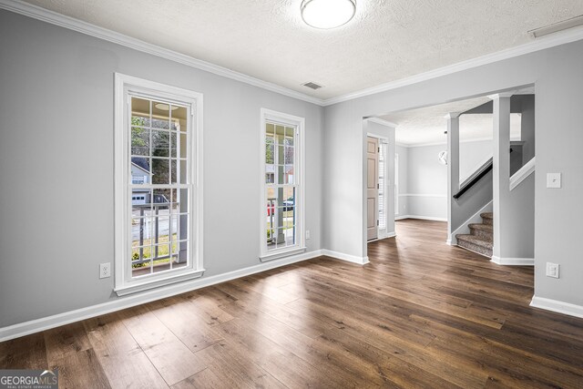 interior space with wood-type flooring, ornamental molding, and a textured ceiling