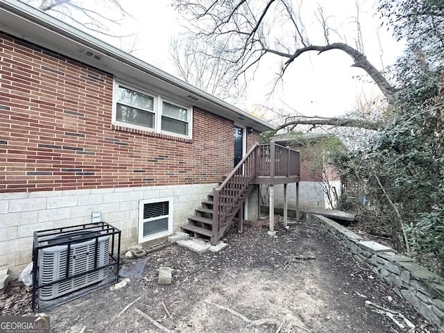 rear view of house with central AC unit and a deck