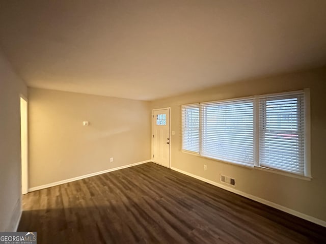 spare room with dark wood-type flooring