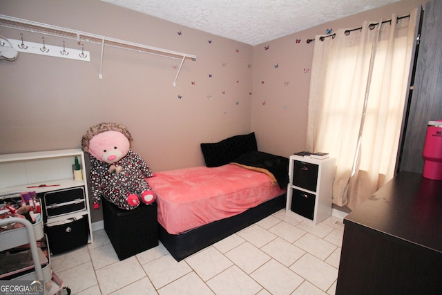 tiled bedroom featuring a textured ceiling