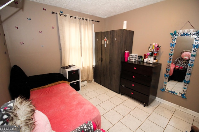 bedroom featuring light tile patterned floors and a textured ceiling