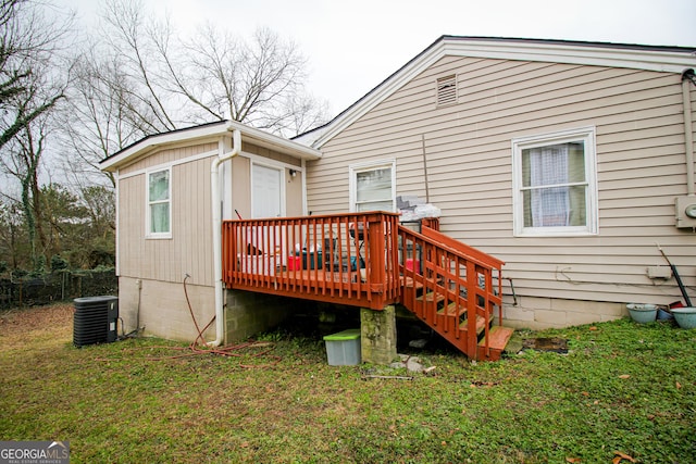 rear view of house with a lawn, a deck, and central air condition unit