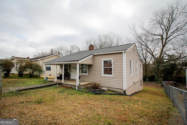 bungalow-style house featuring a front lawn and a patio