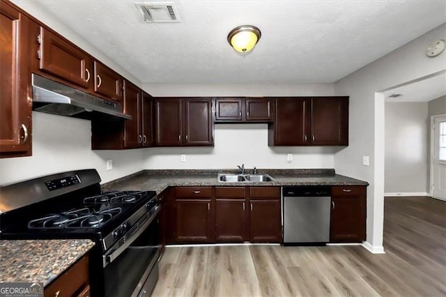 kitchen featuring sink, stainless steel dishwasher, light wood-type flooring, and black gas range