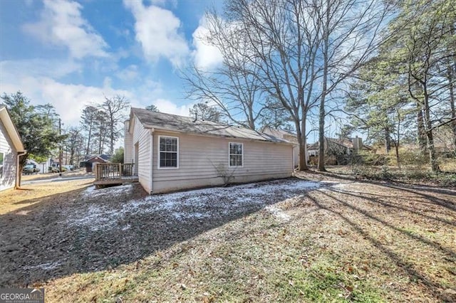 view of property exterior with a wooden deck