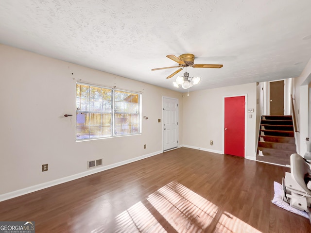 unfurnished living room with dark hardwood / wood-style flooring, ceiling fan, and a textured ceiling